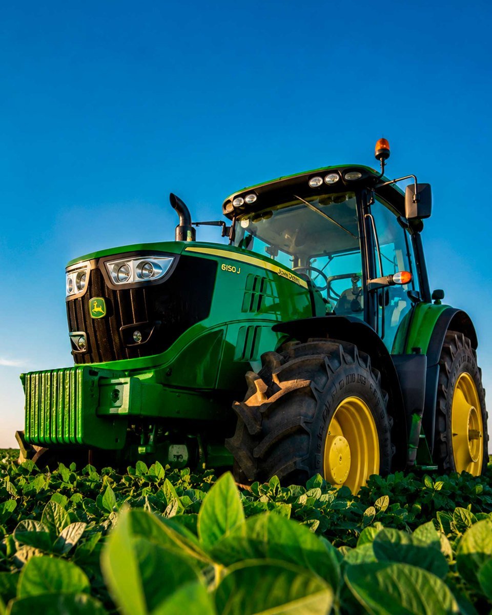 Trator John Deere 6150J em lavoura de soja ao entardecer